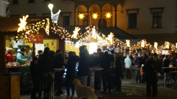 Olomouc, Česká republika, 20 prosince 2018: Vánoční trhy noc, osvětlení s ornamenty hvězdy a ozdoby na stánku stánek s alkoholem punč s ovocnou šťávou, lidé kupují nápoje v šálku — Stock video
