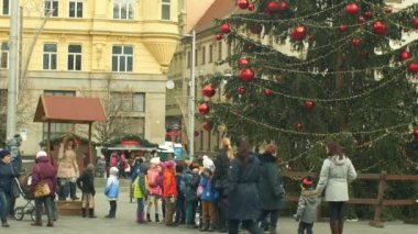 Brno, Çek Cumhuriyeti, 21 Aralık 2018: Noel ağacı aydınlık ve güzel altın süsler ve şişeler kırmızı büyük süslenmiş parlar, çocuk anaokulu yol üzerinden gider, xmas topu
