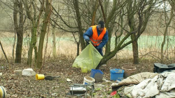 OLOMOUC, REPÚBLICA CHECA, JANEIRO 2, 2019: Homem coleta lixo lixo coleta saco, paisagem florestal na natureza ameaçada, despejo preto de sujeira humana de lixo plástico vários tipos — Vídeo de Stock