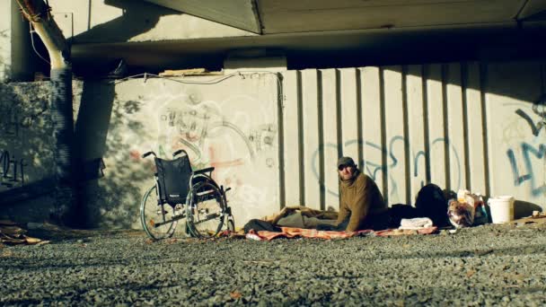Olomouc, Tsjechië, 24 oktober 2018: authentieke emotie van dakloze en een rolstoel ongeldig zonder poten op zijn plaats onder een brug waar ze slapen, begraven in het stadsleven, Europa — Stockvideo