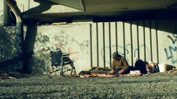 OLOMOUC, RÉPUBLIQUE TCHÈQUE, 24 OCTOBRE 2018 : Authentique émotion des sans-abri et un fauteuil roulant invalide sans jambes en place sous un pont où ils dorment, creusent dans la vie urbaine, Europe — Video