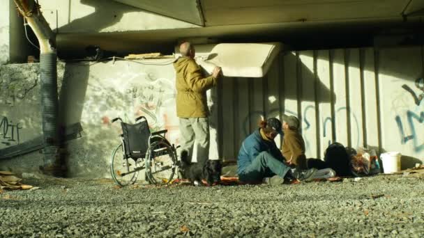 Оломоуць, Чехія, 24 жовтня 2018: автентичні емоції групи бездомних людей і один інвалідний візок без ніжок на місці під мостом, де вони сплять, Європа — стокове відео