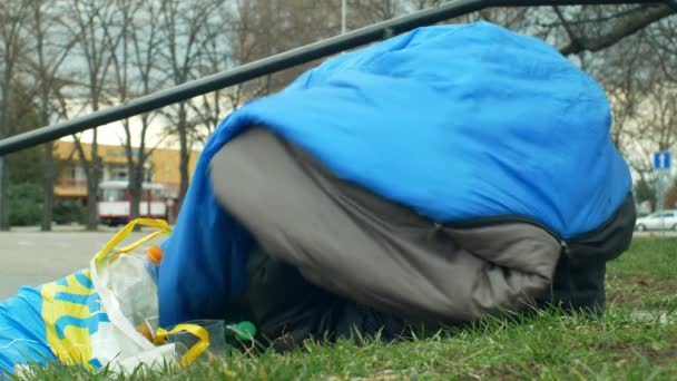 OLOMOUC, REPÚBLICA CHECA, 2 DE ENERO DE 2019: Las personas sin hogar duermen y se despiertan del sueño en el saco de dormir en la calle emoción auténtica cerca de los grandes almacenes de compras, caminar a la gente vida parque de la ciudad — Vídeos de Stock