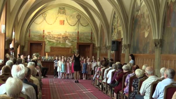 OLOMOUC, REPÚBLICA CHECA, 15 DE ABRIL DE 2018: Coro coral infantil cantando de canta canción folclórica checa Sly panenky silnici, jubilados ancianos sentados en sillas, techo abovedado gótico — Vídeo de stock