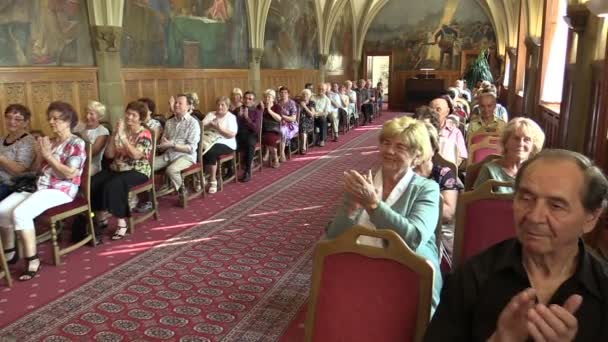 Olomouc, Tschechische Republik, 15. April 2018: Rittersaal im Rathaus von olomouc, Menschen applaudieren und klatschen, Rentner sitzen auf Stühlen, gotische Gewölbedecke, feierlich — Stockvideo