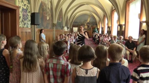 OLOMOUC, CZECH REPUBLIC, APRIL 15, 2018: Korbarn synger tsjekkisk folkesang, gamle pensjonister sitter på stoler, gotisk hvelvtak, Knights Hall – stockvideo