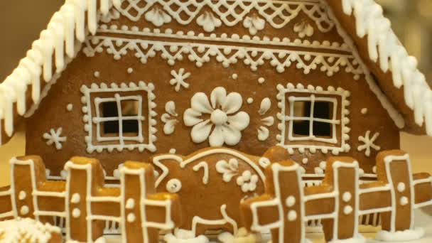 Casa de gengibre e bolo de casa de campo bonito, uma cerca com um banco de porquinho, decorado com uma cereja branca de confeitaria com claras de ovo batidas, trabalho criativo popular, decoração para o tempo de Natal — Vídeo de Stock