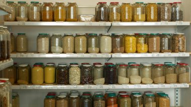 Ambalajsız hammadde, sağlıklı beslenme geniş tahıl çeşitleri, baklagiller, kavanozlarda kurutulmuş meyveler ve cam şişeler kendi poşetleri üzerinde, geri dönüşüm torbaları yeniden mağaza