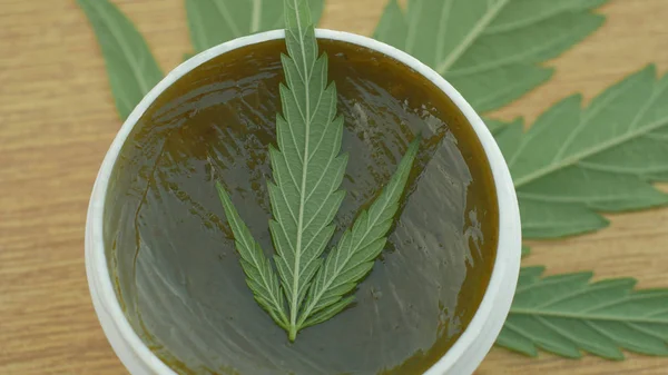 Crema medicinal de cannabis de cáñamo y hoja de cannabidiol CBD cosechada seca de semillas de calidad para la producción de ungüentos, alivia el dolor, antibacteriano y calmante, semillas de capullo grande con pistilos y estigmas — Foto de Stock