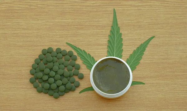 Crema de cannabis y tabletas cápsulas medicinales o pastillas de cáñamo y hoja de cannabidiol CBD cosechada seca de semillas de calidad para la producción de ungüentos desarrollados, alivia el dolor, medicamentos antibacterianos — Foto de Stock