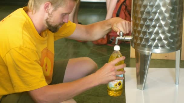 Прага, Чехія, 25 травня 2019: соняшникова олія органічна якість біо, сталева бочка або чаша, для холодної їжі і смажених продуктів харчування, людина наливає золоту олію в магазині магазин — стокове відео
