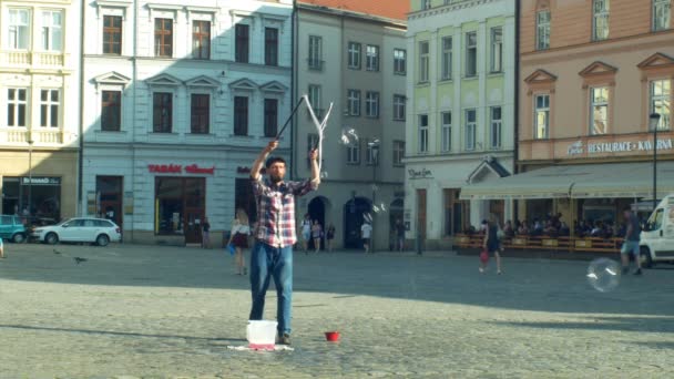 Olomouc, Çek Cumhuriyeti, 11 Haziran 2019: Çubuklarda deterjan sabunu ve ipi kullanarak baloncuk yapmak, büyük baloncuk, sokak sanatları adamı rüzgar sokak yapar ve para dileniyor, sabunlu sanatçı — Stok video