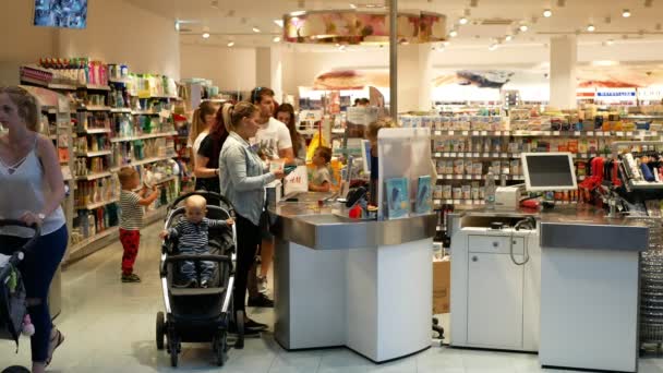PRAGA, REPÚBLICA CHECA, 25 DE MAYO DE 2019: Europeos con compras de farmacias farmacias farmacias, taquilla con una joven, yendo desde el centro comercial, pago de dinero — Vídeos de Stock