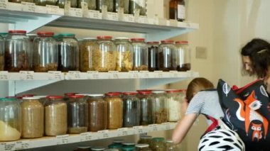 Prag, Çek Cumhuriyeti, 30 Mayıs 2019: Ambalajsız alışveriş, ağırlık ve ödeme, hindistan cevizi kurutulmuş meyveler, kavanozlarda yulaf ezmesi ve kendi çantalarında cam şişeler