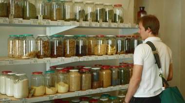 Prag, Çek Cumhuriyeti, 30 Mayıs 2019: Ambalajsız alışveriş, ağırlık ve ödeme, sağlıklı geniş kurutulmuş meyve çeşitleri, kavanozlarda fındık ve kendi çantalarında cam şişeler