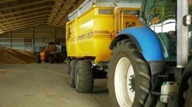 Olomouc, Çek Cumhuriyeti, 20 Ağustos 2019: Stok veya depo kazık buğday veya arpa mağazası, traktör New Holland T 7060 ve siding tren Bednar yükleme, binmek geri