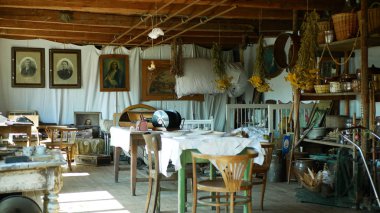 Olomouc, Çek Cumhuriyeti, Eylül 5, 2019: Geleneksel Moravya yazlık eski halk Hana masa ve kurutulmuş otlar ile. Köylü yatak ve kil tencere iç benzersiz kulübe. Hıristiyan resimleri