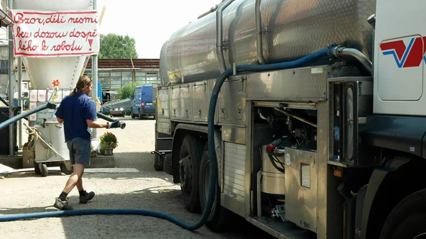 Olomouc, Çek Cumhuriyeti, 25 Mayıs 2019: Çiftlikten süt pompalanan süt tankı yaprakları, kamyon köy yetiştiriciliği, yük taşımacılığı römork kamyon, teknisyen servis el işçisi — Stok fotoğraf