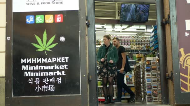 Prag, Tjeckien, 9 september 2019: Handla hampa cannabis medicinsk, säljer även fröprodukter, missbrukare använder droger, skyltbutik med cannabissymboler blad, människor — Stockvideo
