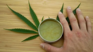 Krem kenevir kenevir merhemi, elinde tıbbi kenevir merhemi CBD deri yaprakları, vücut masajı gevşetici etkisi, ağrı kesiciyi rahatlatır, merhem rahatlatıcı, antibakteriyel marihuana, THC