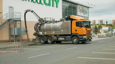OLOMOUC, CZECH REPUBLIC, JUNE 29, 2020: Sewer cleaning tank truck car pipe drain cleaning shaft septic cesspool pumping suction hose under pressure, sump contains pollution sludge sewage wastewater clipart