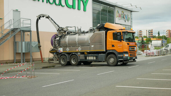 OLOMOUC, CZECH REPUBLIC, JUNE 29, 2020: Sewer cleaning tank truck car pipe drain cleaning shaft septic cesspool pumping suction hose under pressure, sump contains pollution sludge sewage wastewater
