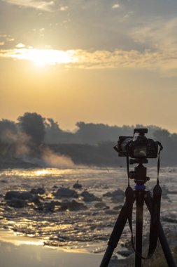 Güneş doğarken çekim bir tripod üzerinde kamera