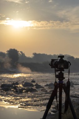 Güneş doğarken çekim bir tripod üzerinde kamera