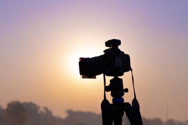 Güneş doğarken çekim bir tripod üzerinde kamera