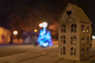 Noel ışıkları arka planda bir masada küçük mum evi