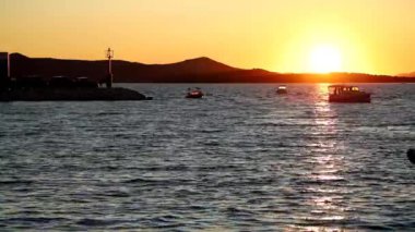 Hırvatistan 'ın Biograd kentinde gün batımında yat ve botlar marinaya girip çıkıyor