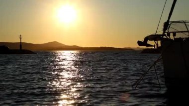 Hırvatistan 'ın Biograd kentinde gün batımında yat ve botlar marinaya yavaş çekimde girip çıkıyor