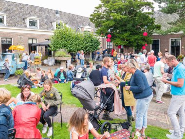 Dokkum, Hollanda - 20 Ağustos 2017: İnsanlar zevk aperatifler ve içecekler sokak gıda festival üzerinde eski Bolsward tarihi kasaba Friesland yetimhanede Bahçe