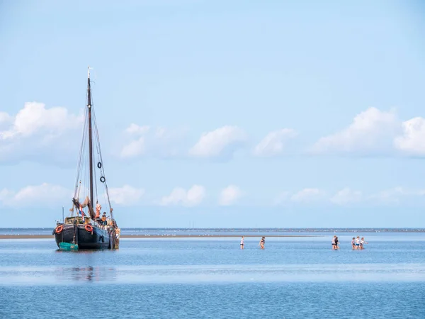 Grupa Młodych Ludzi Brodząc Wodzie Płytkiej Jachtu Mieliźnie Czasie Odpływu — Zdjęcie stockowe