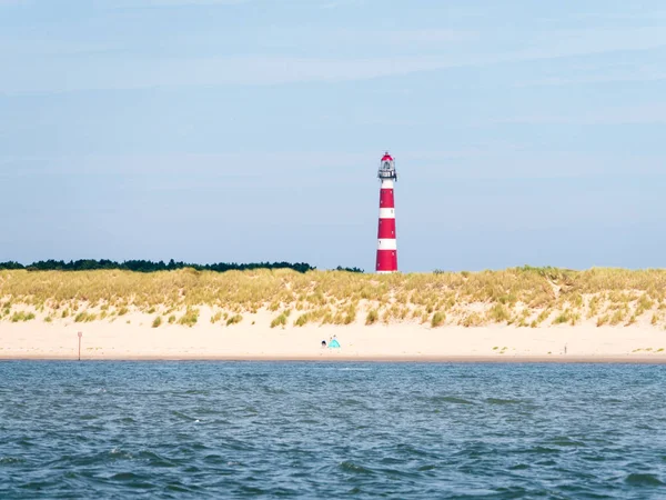 Beach and lighthouse of Ameland island in Wadden Sea, Friesland, Netherlands