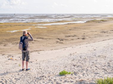 Terschelling, Hollanda üzerinde Wadden Denizi Boschplaat beach üzerinden düşük gelgit gelgit daireler bakarak dürbün ile komuta sizde