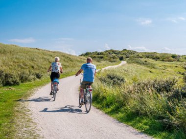 Ameland, Hollanda - 27 Ağustos 2017: Arkadan görünüş insanlar Bisiklet bisiklet yolu doğa rezervatı Het Oerd Frizce Adası Ameland, Friesland, Hollanda nın dunes içinde üzerindeki sürme