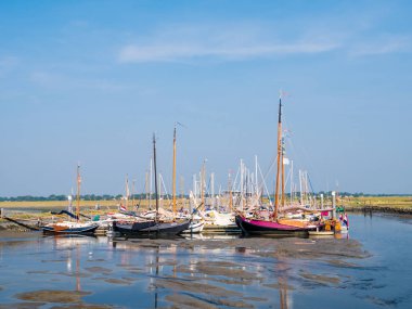 SCHIERMONNIKOOG, NETHERLANDS - AUG 29, 2017: Sailing boats in marina at low tide, West Frisian island Schiermonnikoog, Netherlands