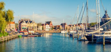ENKHUIZEN, NETHERLANDS - OCT 6, 2017: Panorama of old harbour with boats and quayside in historic city of Enkhuizen, North Holland, Netherlands
