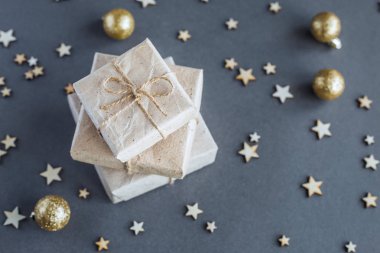 Mevcut kutuları kraft kağıt gri arka plan üzerinde sarılı. Noel kavramı