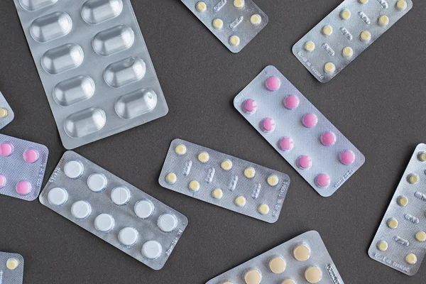 Tabletler Hapları Gri Arka Plan Üzerinde Çeşitli Ilaç Ambalajı — Stok fotoğraf