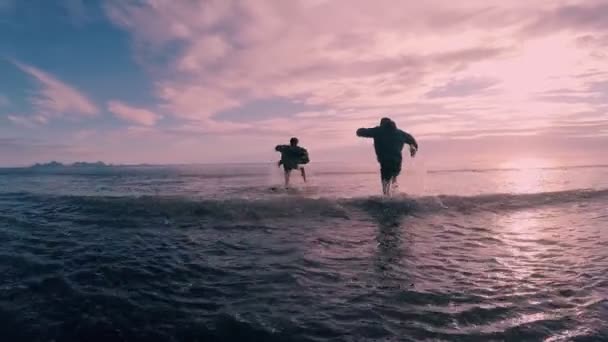 Два Лучших Друга Одежде Бегущих Морской Воде Закате — стоковое видео