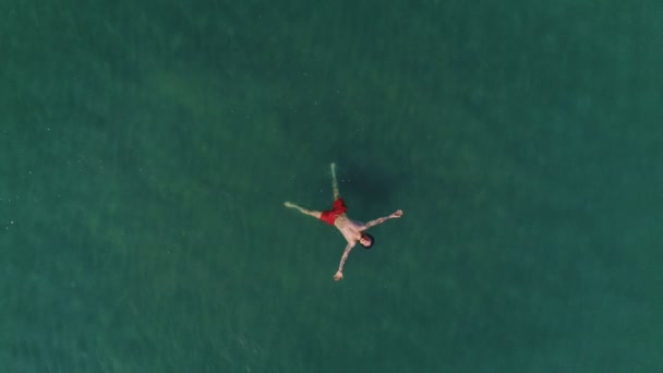 Vista Aérea Del Hombre Con Pantalones Cortos Baño Rojos Flotando — Vídeo de stock