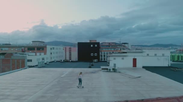 Teenage Girl Riding Skateboard Building Roof Drone Video — Stock Video