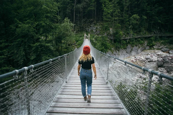 Junge Wanderin läuft auf Hängebrücke — Stockfoto