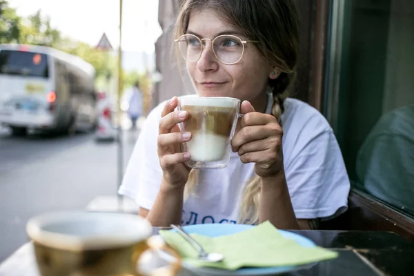 Мила гарненька молода жінка п'є каву молоко піни — стокове фото