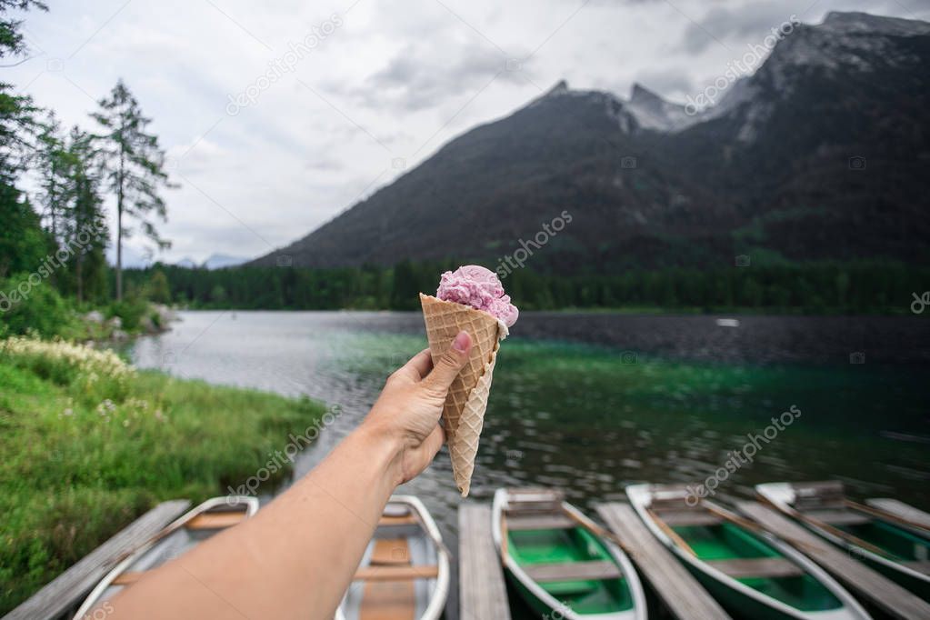 Female hand hold icecream at lake side in mountain