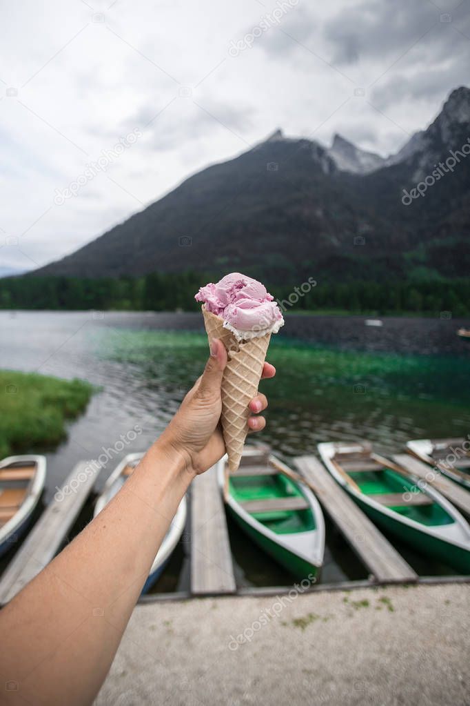 Female hand hold icecream at lake side in mountain