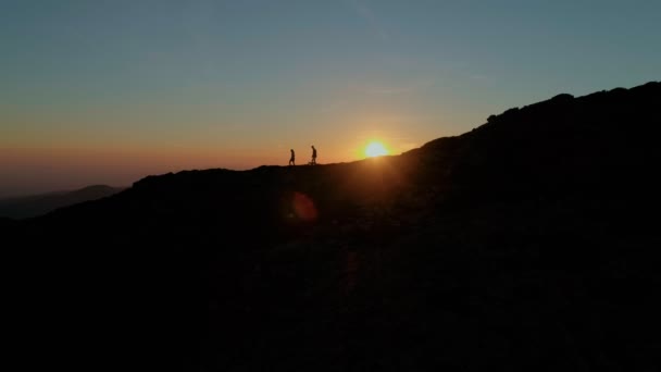 Пара прогулок на вершине горы или гребень на закате — стоковое видео