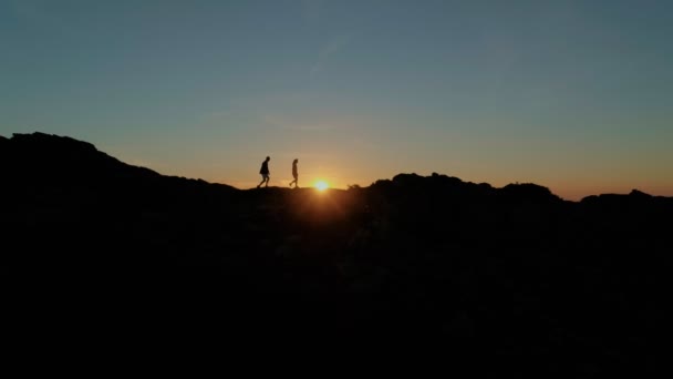 Пара прогулок на вершине горы или гребень на закате — стоковое видео